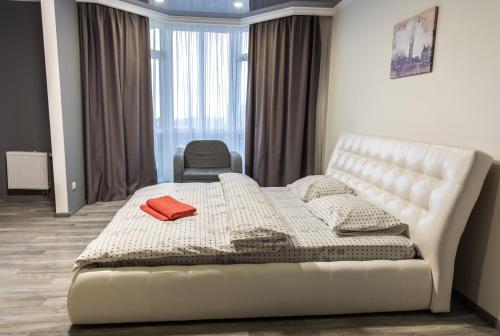 a bedroom with a white bed and a chair at Видовая квартира в новострое в центре Киева in Kyiv