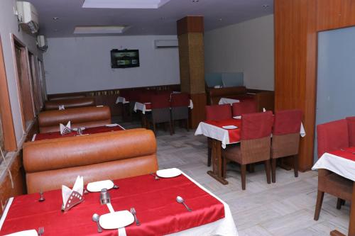 un restaurant avec des tables et des chaises rouges et une salle à manger dans l'établissement HOTEL SHIVAM, à Howrah