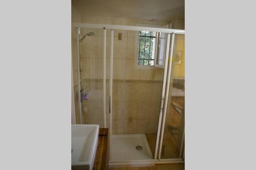 La salle de bains est pourvue d'une douche avec une porte en verre. dans l'établissement IA ORANA, à Gargas
