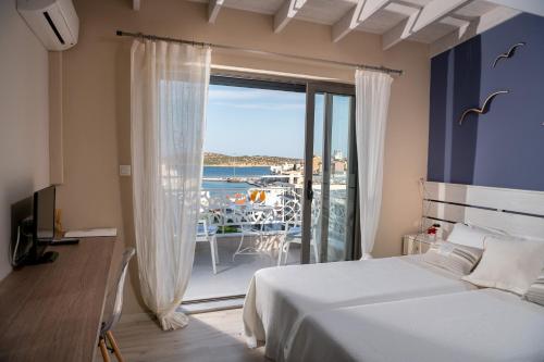 een slaapkamer met een groot raam met uitzicht op de oceaan bij Emerald Lake Studios in Agios Nikolaos