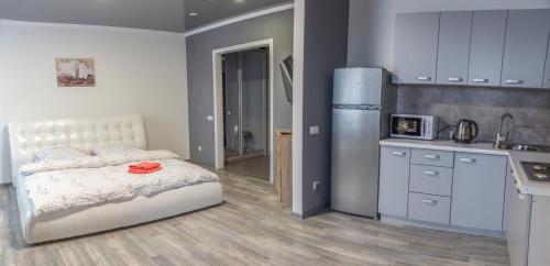 a bedroom with a bed and a kitchen with a refrigerator at Видовая квартира в новострое в центре Киева in Kyiv