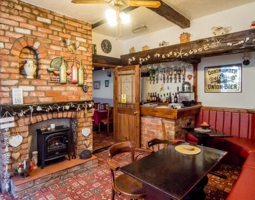 un bar con chimenea y una mesa en una habitación en The Tudor Lodge, en Skegness