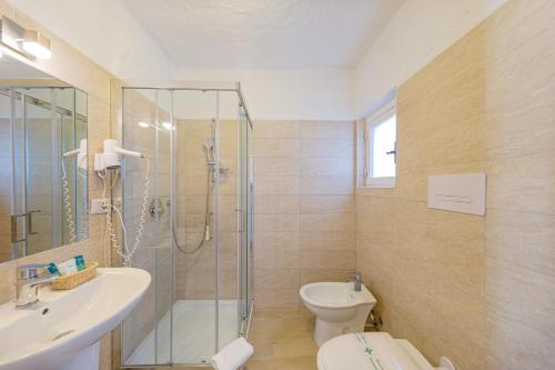 a bathroom with a toilet a sink and a shower at Hotel Mare Blue in Olbia