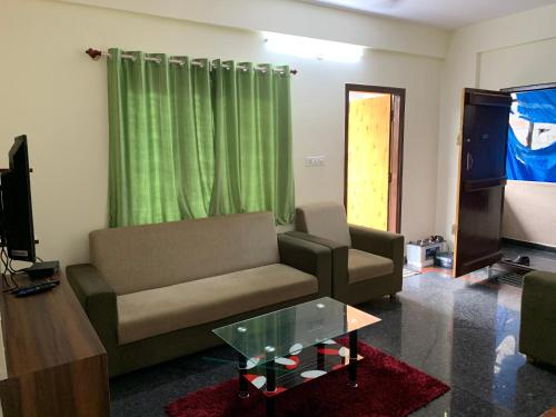 a living room with a couch and a tv at Haven Homes in Yelahanka