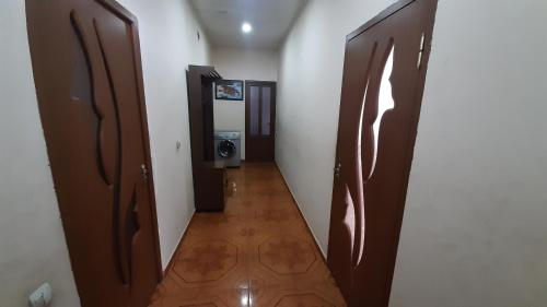 a hallway with wooden doors and a hallway with a bathroom at PIT STOP B&B Guesthouse in Urtsʼadzor