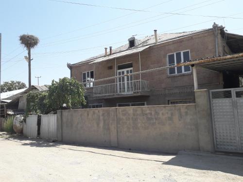 a brick house with a fence in front of it at PIT STOP B&B Guesthouse in Urtsʼadzor