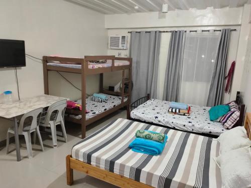a room with two bunk beds and a table at Mhavic family room ,group friend good for 6 guest in Manila