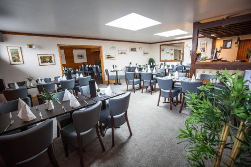 a dining room with tables and chairs in a room at Smithfield Hotel in Dounby