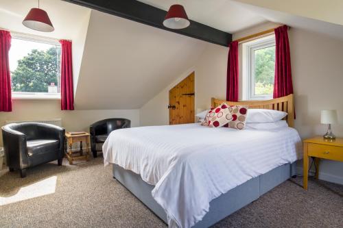 1 dormitorio con 1 cama grande y 2 ventanas en Trengilly Wartha Inn en Constantine
