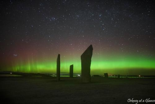 an aurora in the sky with pillars in a field at Smithfield Hotel in Dounby