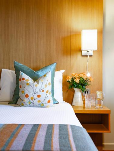 a bed with a pillow and a table with a lamp at Lanhydrock Hotel & Golf Club in Bodmin