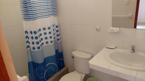 uma casa de banho com um lavatório, um WC e uma cortina de chuveiro. em Casamar em Máncora