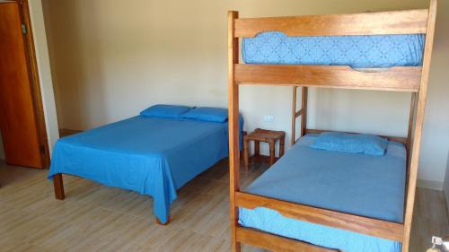 2 Etagenbetten mit blauer Bettwäsche in einem Zimmer in der Unterkunft Casamar in Máncora