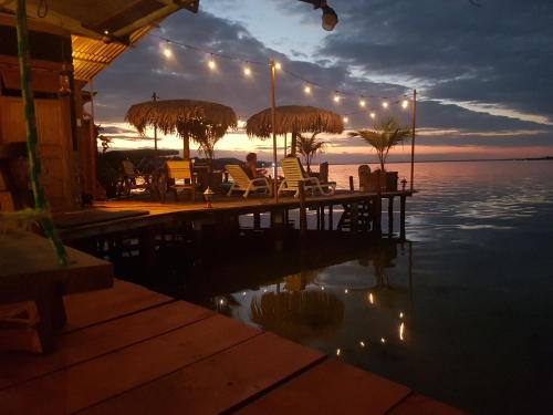 a patio area with tables, chairs and umbrellas at Barrbra BnB Over The Sea in Bocas Town