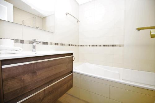 een badkamer met een bad, een wastafel en een bad tubermottermott bij Apartment PP33 in Estepona