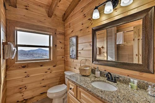 a bathroom with a toilet sink and a mirror at Elevated Cabin Bordering Smoky Mountain Natl Park in Bryson City