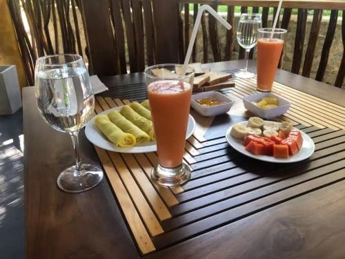 un tavolo con piatti di cibo e bicchieri di succo di skyresort a Tangalle