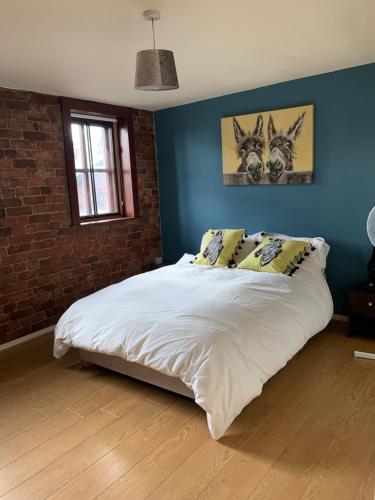 um quarto com uma grande cama branca com paredes azuis em 2 Bed Duplex Penthouse Apartment by Mathew Street Sleeps 6 em Liverpool