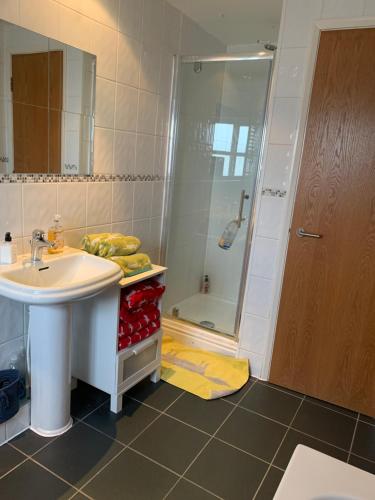 a bathroom with a sink and a shower at 2 Bed Duplex Penthouse Apartment by Mathew Street Sleeps 6 in Liverpool