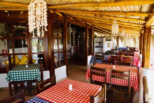 un restaurante con mesas y sillas rojas y azules en Hotel Smiling Crab, en Canoas de Punta Sal
