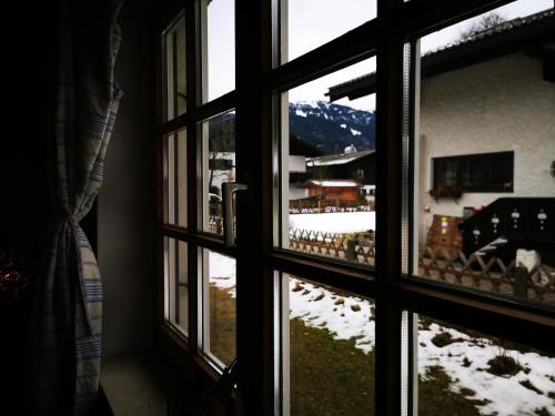 a view of a snowy mountain through a window at Heidi's Home in Garmisch-Partenkirchen