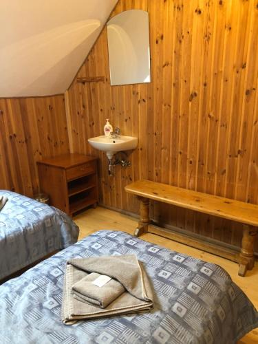 a bedroom with a bed and a sink in a room at Viesu nams Vālodzes in Sigulda