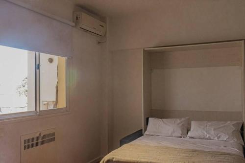 a bedroom with a bed and a window at RECOLETA APART in Buenos Aires