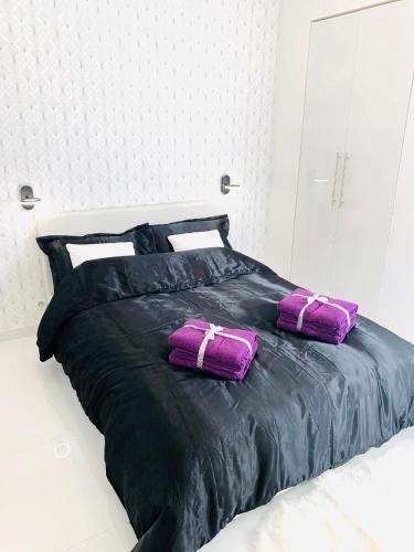 two purple pillows sitting on a black bed at monaco, CHAMBRE LUXE, à 250M casino in Beausoleil