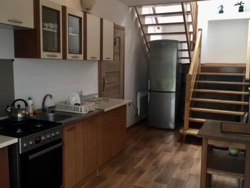 a kitchen with a stove and a refrigerator at Kwatera Pod Bukowa Gora in Zwierzyniec