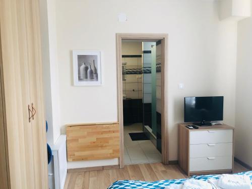 a bedroom with a television and a walk in closet at Oázis Panzió in Gyenesdiás