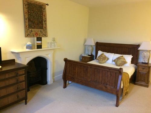 a bedroom with a large bed and a fireplace at Otterburn Castle in Newcastle upon Tyne