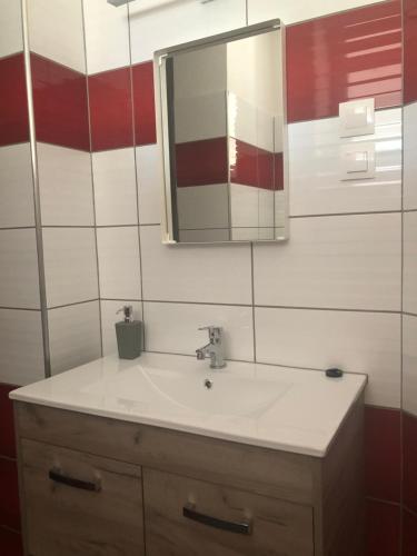 a bathroom with a sink and a mirror at Oázis Panzió in Gyenesdiás