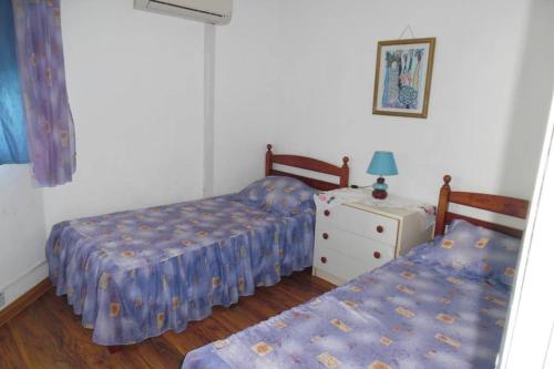 1 dormitorio con 2 camas y mesa con lámpara en Villa Raybaud Résidence Les Cygnes, en Pereybere