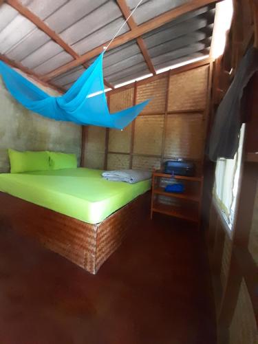 a bed in a room with a blue umbrella at Som PalmGarden in Ko Lanta