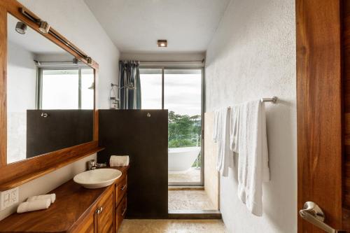 a bathroom with a sink and a mirror and a tub at Casa ChaChaCha in San Juan del Sur