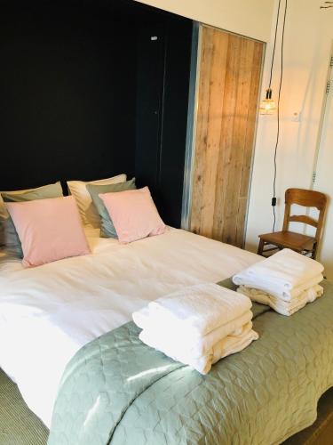 a bedroom with a bed with towels on it at 'Room Eleven' aan de Vecht in Vreeland
