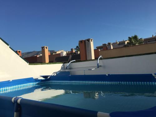 a swimming pool with blue water in front of a building at Apartment with private patio in Fuengirola