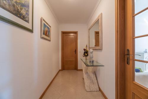 a hallway with a door and a table and a window at Apartamento Praia da Oura in Albufeira
