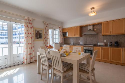 a kitchen with a table with chairs and a dining room at Apartamento Praia da Oura in Albufeira