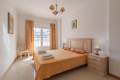 a bedroom with a large bed and a window at Apartamento Praia da Oura in Albufeira