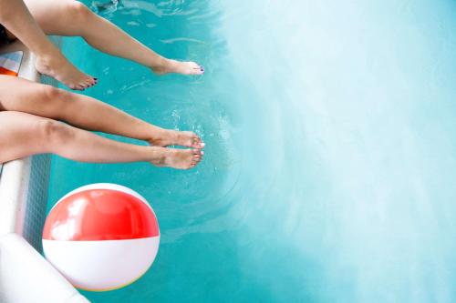two girls in a swimming pool with a ball at Hyatt House Cypress / Anaheim in Cypress