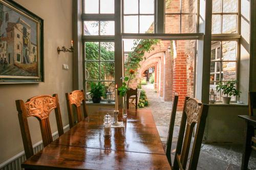 une table à manger avec des chaises et une grande fenêtre dans l'établissement Hotel Haase, à Lübeck