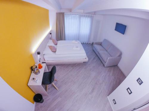 a small living room with a bed and a couch at Agritur Verderame in Trento
