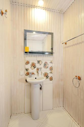 a white bathroom with a sink and a mirror at Doroga Dodomu in Mykulychyn