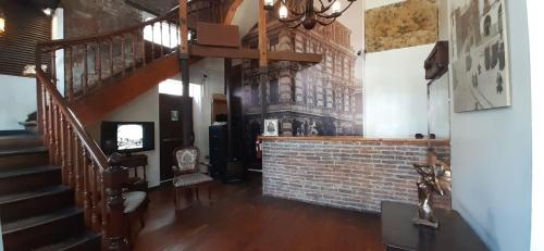 a living room with a staircase and a brick wall at Hotel Reina Victoria in Valparaíso