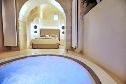 una camera da letto con una grande vasca al centro di una stanza di Anima Pietra Luxury Suite a Matera
