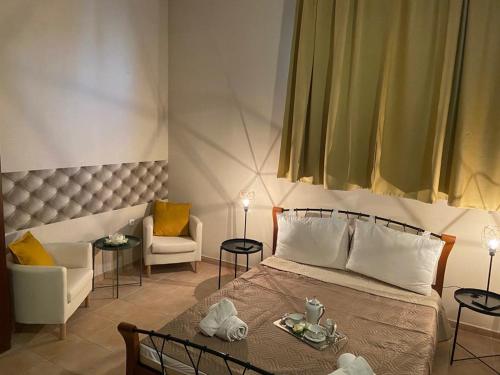 um quarto com uma cama, uma mesa e cadeiras em VALENTINA LUXURY em PalaiónTsiflíkion