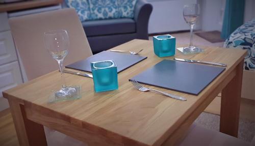 drewniany stół z dwoma kieliszkami do wina i stół z w obiekcie A Beautiful Apartment with Stunning Sea Views & Private Balcony w Bournemouth