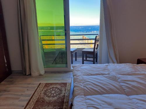 a bedroom with a bed and a door to a balcony at Diamond Dahab House in Dahab