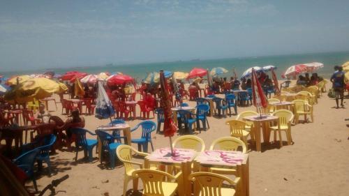 a group of tables and chairs on the beach at Praia de Itaparica Ed Green Diamond Vila Velha ES in Itaparica